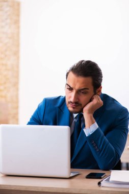 Genç bir erkek işçi ve ofiste çok fazla iş var.