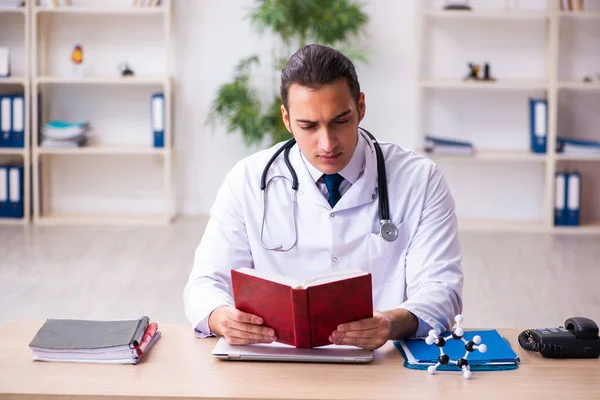 Молодий студент-лікар читає книгу в клініці — стокове фото