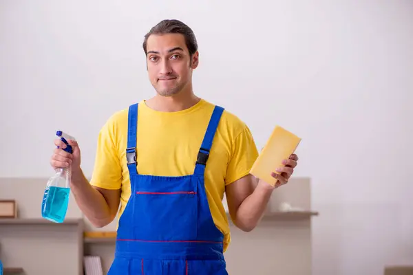 Joven contratista masculino limpiando la casa —  Fotos de Stock