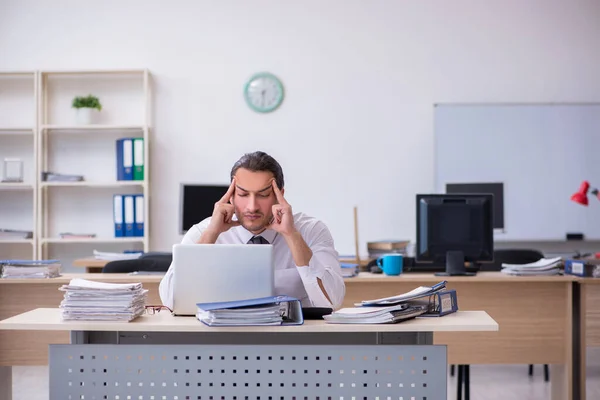 Giovane dipendente maschio infelice con il lavoro eccessivo — Foto Stock