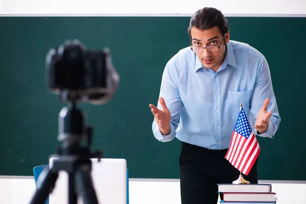 Young handsome teacher recording video for his blog