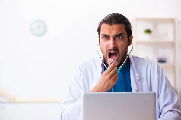 Joven doctor sosteniendo fonendoscopio — Foto de Stock