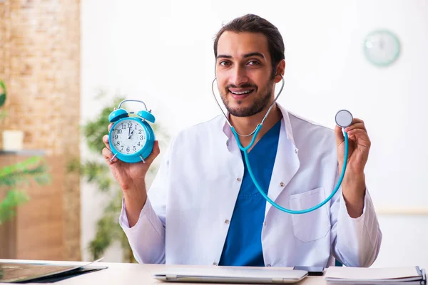 Joven médico masculino en concepto de gestión del tiempo — Foto de Stock