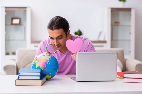 Estudante do sexo masculino buscando amor ao redor do mundo via Internet — Fotografia de Stock