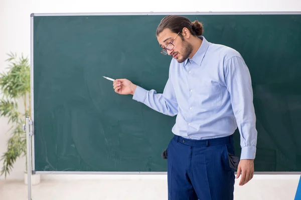 Joven profesor mal pagado en el aula — Foto de Stock