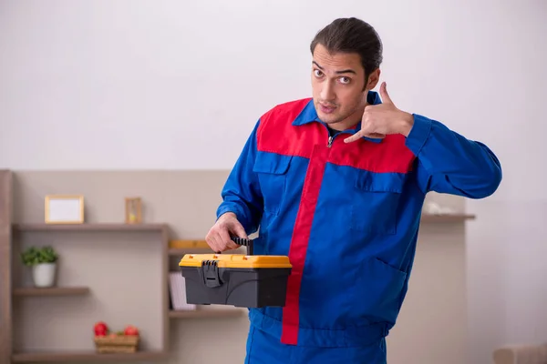 Joven contratista masculino reparando muebles en interiores —  Fotos de Stock