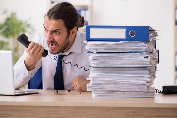 Joven hombre de negocios descontento con el trabajo excesivo en la oficina —  Fotos de Stock