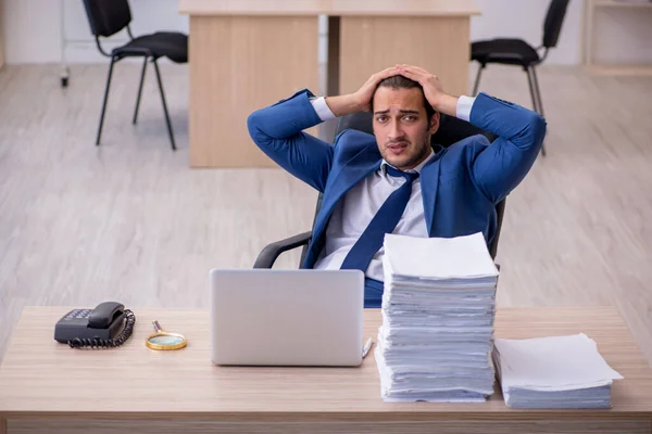 Jeune employé masculin et trop de travail au bureau — Photo