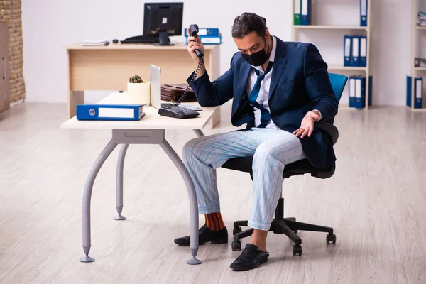 Joven empleado masculino durante pandemia en el lugar de trabajo — Foto de Stock