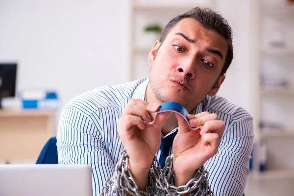 Geketende mannelijke werknemer werkzaam in het kantoor — Stockfoto