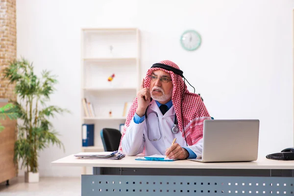 Vecchio medico arabo maschio che lavora in clinica — Foto Stock