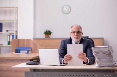 Ofiste çalışan yaşlı bir erkek.