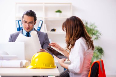 Genç işadamı ve bayan mimar yeni projeyi tartışıyor