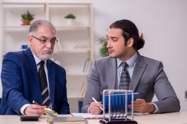 Masada iki iş adamı ve meditasyon topu var.