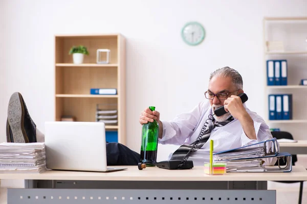 Idős férfi alkalmazott alkoholt iszik az irodában — Stock Fotó