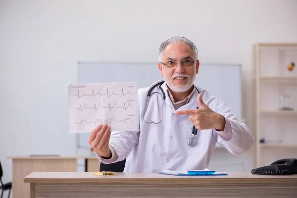 Klinikte çalışan yaşlı bir erkek kardiyolog. — Stok fotoğraf