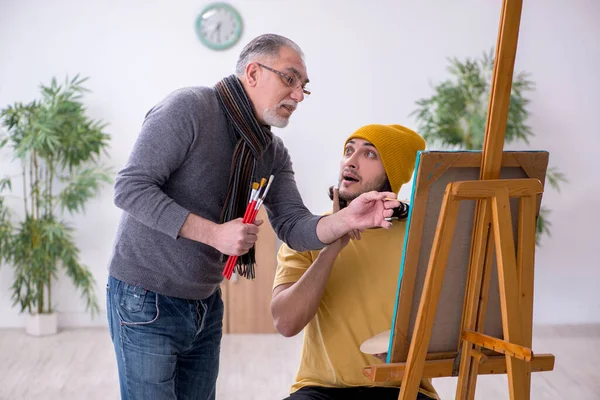 Mladý muž se učí od starého malíře — Stock fotografie