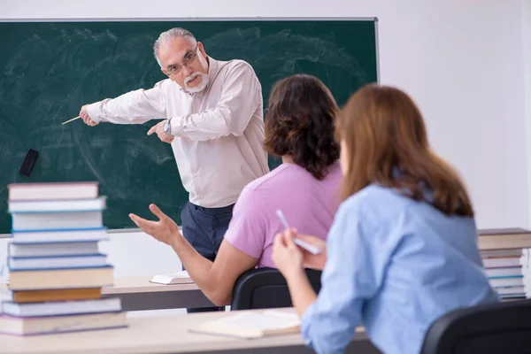 Oude scheikundeleraar en twee leerlingen in de klas — Stockfoto