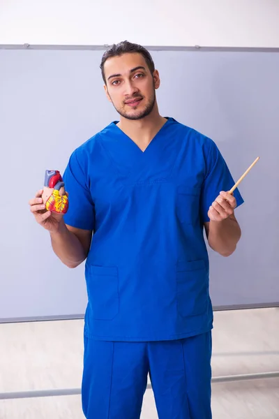 Młody mężczyzna lekarz kardiolog przed tablicą — Zdjęcie stockowe