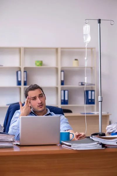 Giovane dipendente maschile che soffre sul posto di lavoro — Foto Stock