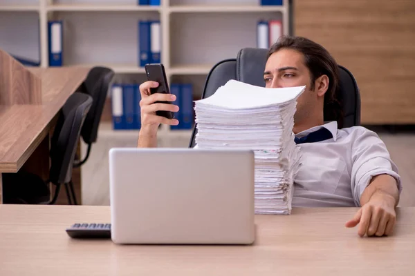 Jovem funcionário masculino infeliz com excesso de trabalho no escritório — Fotografia de Stock