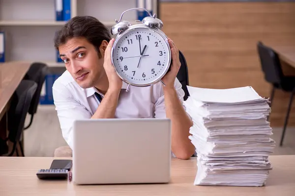 Νεαρός άνδρας υπάλληλος στην έννοια διαχείρισης του χρόνου στο γραφείο — Φωτογραφία Αρχείου