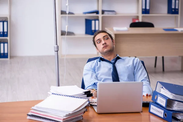 Ung manlig anställd som lider på arbetsplatsen — Stockfoto