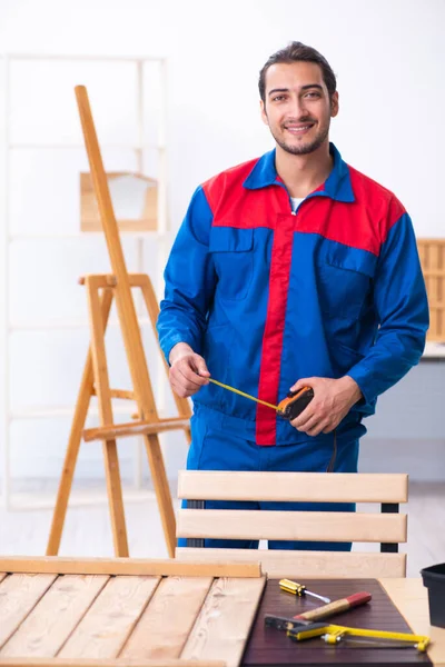Jonge mannelijke aannemer werkzaam in werkplaats — Stockfoto