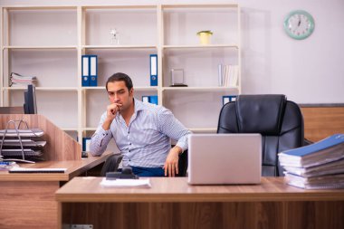 Ofiste çalışan genç bir erkek.