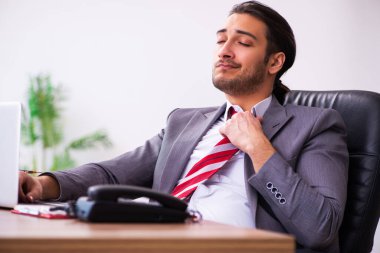 Ofiste çalışan genç bir erkek.