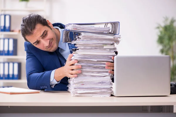 Joven empleado masculino infeliz con el trabajo excesivo — Foto de Stock