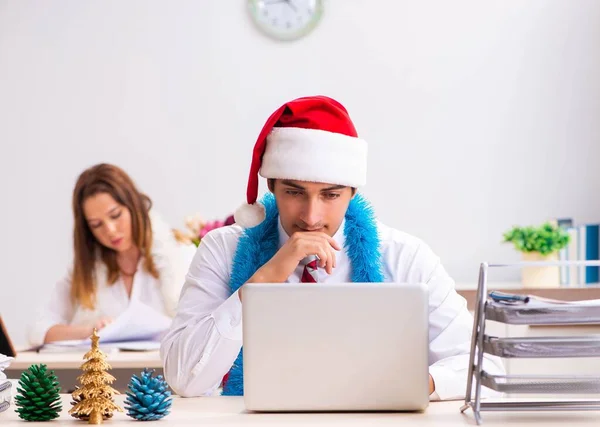 Man and woman working at the office on Cristmass eve