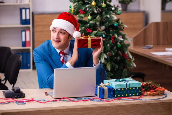 Jonge mannelijke werknemer viert Kerstmis op het werk — Stockfoto