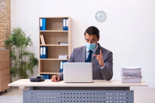 Young male employee wearing mask during pandemic — Stock Photo, Image