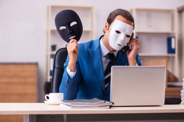 Ofiste maske takan genç bir erkek.