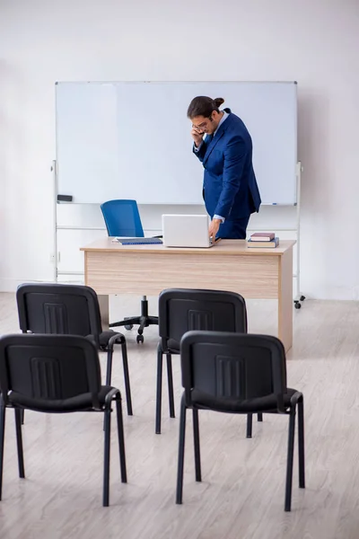 Young male business trainer in the office during pandemic