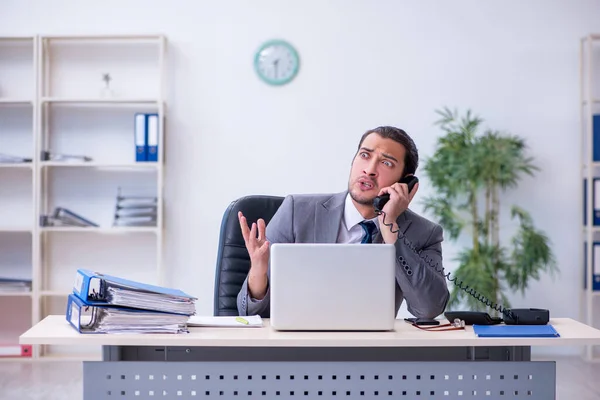 Ung manlig anställd missnöjd med överdrivet arbete på kontoret — Stockfoto