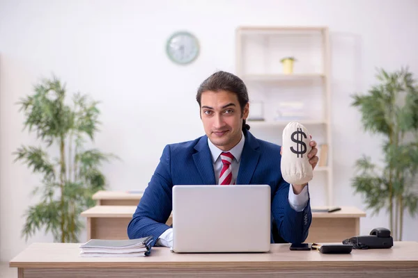 Jeune employé masculin tenant sac d'argent dans le bureau — Photo