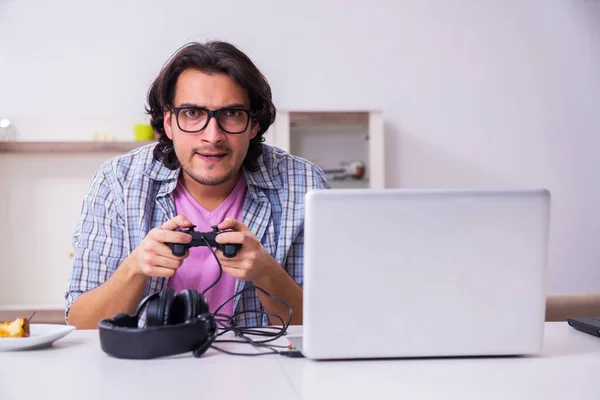 Jeune étudiant masculin jouant à des jeux informatiques à la maison — Photo