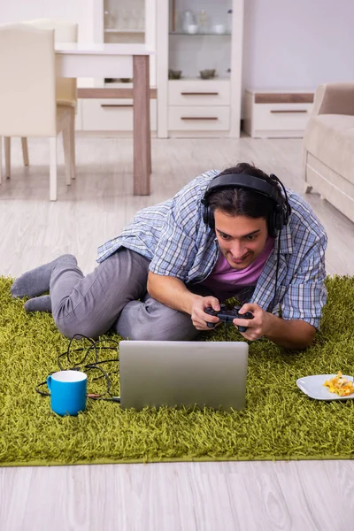 Jonge mannelijke student die thuis computerspelletjes speelt — Stockfoto