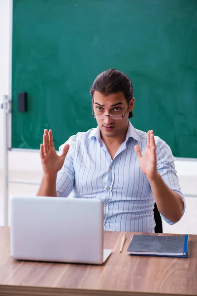 Jonge mannelijke leraar voor schoolbord — Stockfoto