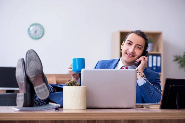 Junge männliche Angestellte trinkt in der Pause Kaffee — Stockfoto