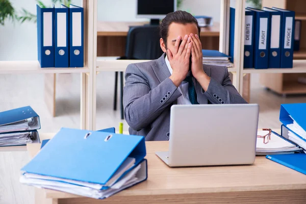 Junge männliche Mitarbeiter und zu viel Arbeit im Büro — Stockfoto