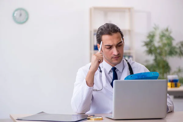 Young male doctor taking notes at the hospital — Stock Photo, Image