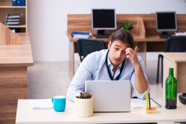 İş yerinde alkol alan genç bir erkek işçi.