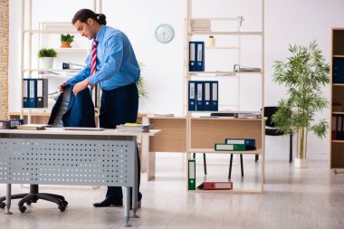 Genç erkek çalışan iş yerinde spor egzersizleri yapıyor.