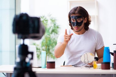 Genç erkek kozmetikçi blogu için video kaydediyor.