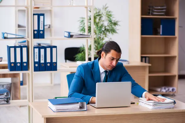 Jovem e bonito empregado sentado no escritório — Fotografia de Stock