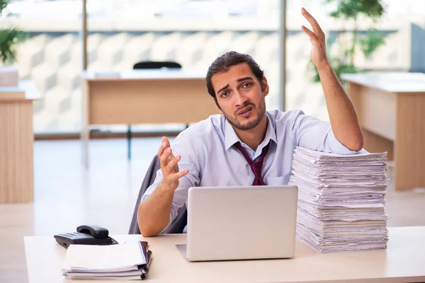 Giovane dipendente maschio infelice con un lavoro eccessivo in ufficio — Foto Stock