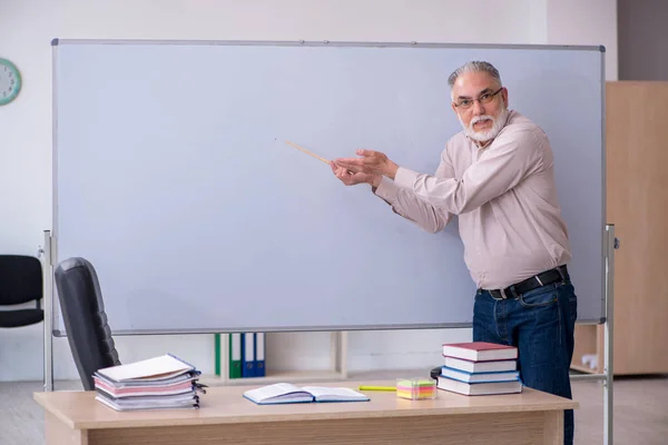 교실에 앉아 있는 나이든 남자 교사 — 스톡 사진